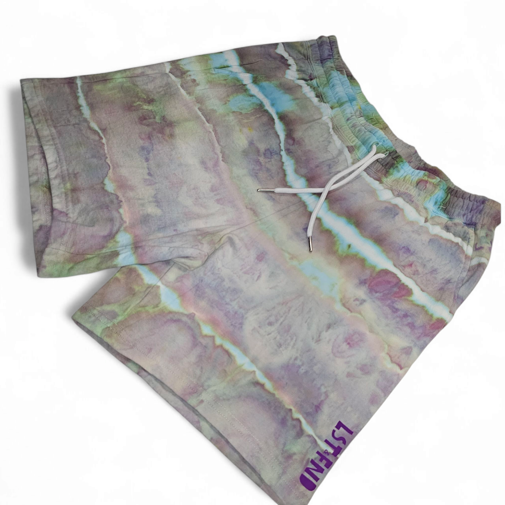 “Alchemy Lights tie-dye shorts with purple and teal stripe pattern, LST FND logo on hem”
